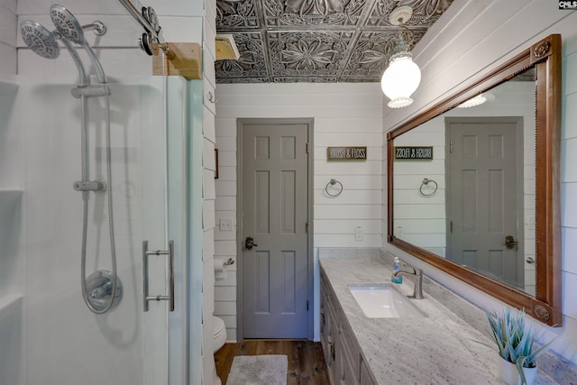 full bathroom featuring vanity, an ornate ceiling, toilet, a shower stall, and wood finished floors