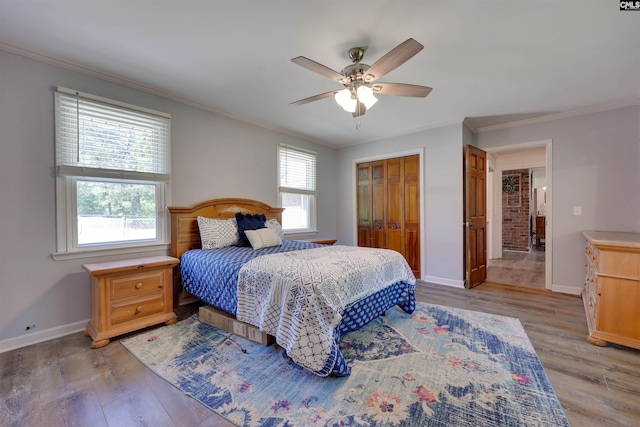 bedroom featuring baseboards, ornamental molding, and light wood finished floors