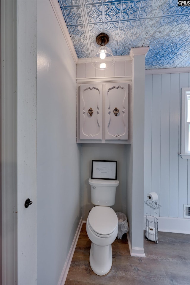 bathroom with baseboards, an ornate ceiling, toilet, and wood finished floors