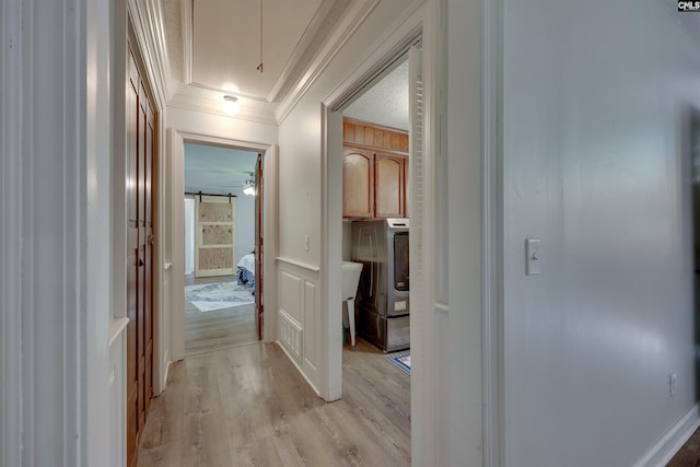 corridor with crown molding, visible vents, attic access, and light wood-style floors