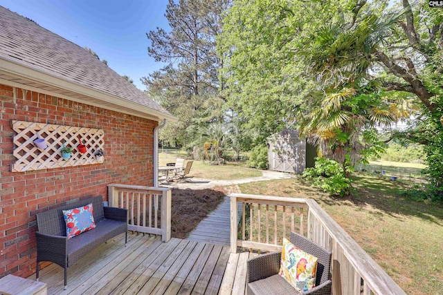 wooden terrace featuring a lawn, a shed, and an outbuilding