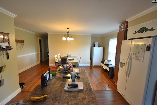 kitchen featuring freestanding refrigerator, dark wood-style flooring, crown molding, and white refrigerator with ice dispenser