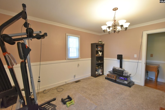 workout area with an inviting chandelier, crown molding, and carpet