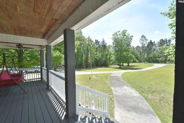 wooden deck featuring a lawn and a porch