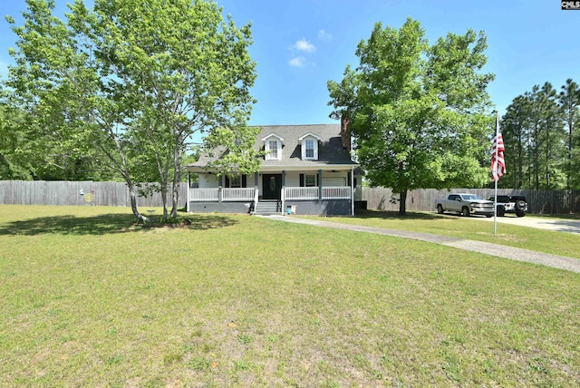 view of front of home with covered porch, fence, and a front lawn