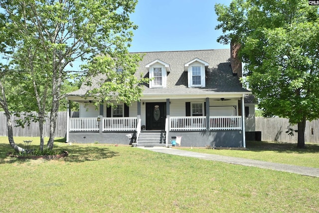 cape cod home featuring fence, a chimney, a porch, and a front lawn