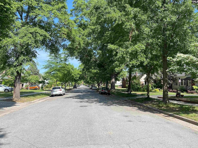 view of street featuring a residential view, sidewalks, and curbs