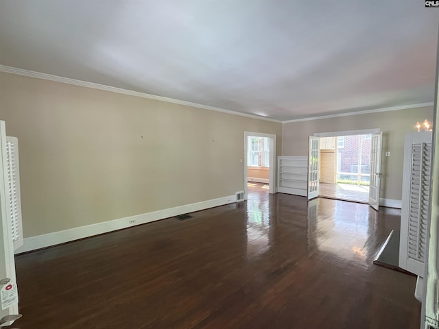 unfurnished room with crown molding, baseboards, dark wood finished floors, and visible vents