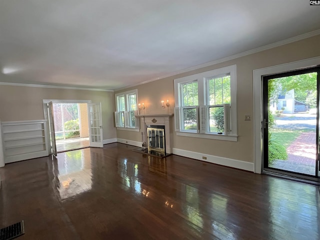 unfurnished living room featuring crown molding, baseboards, a glass covered fireplace, and wood finished floors