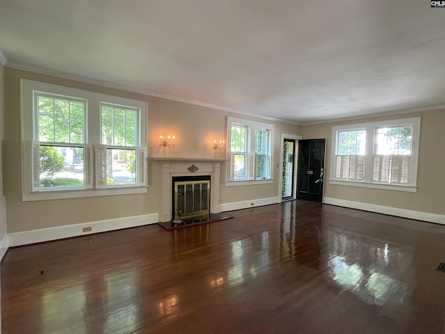unfurnished living room featuring visible vents, crown molding, wood finished floors, baseboards, and a glass covered fireplace