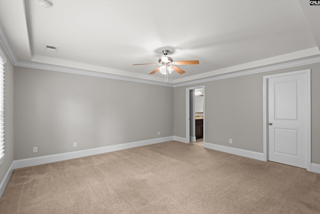 interior space with visible vents, a ceiling fan, a tray ceiling, and light carpet