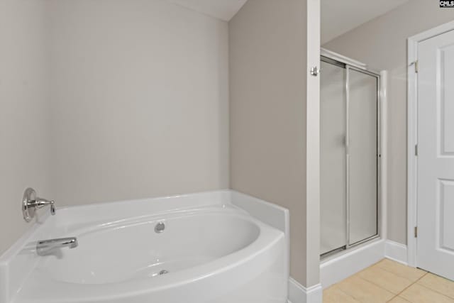 bathroom featuring tile patterned floors, a stall shower, and a bath