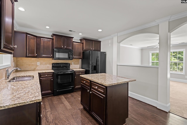 kitchen featuring a sink, arched walkways, black appliances, and visible vents