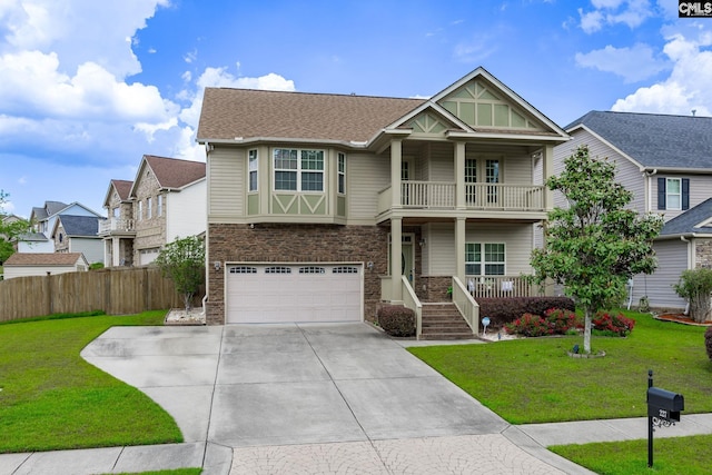 craftsman inspired home with a front lawn, fence, a balcony, an attached garage, and driveway