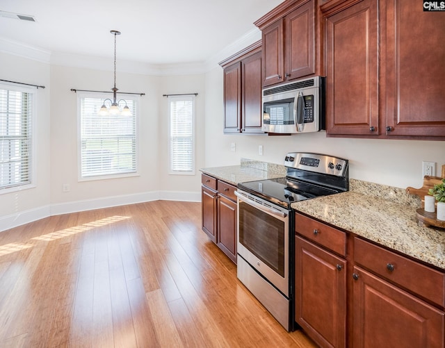 kitchen with a notable chandelier, appliances with stainless steel finishes, light wood finished floors, baseboards, and pendant lighting