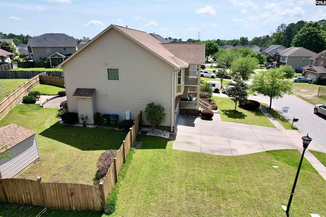 view of side of home with a lawn, a fenced backyard, and a residential view