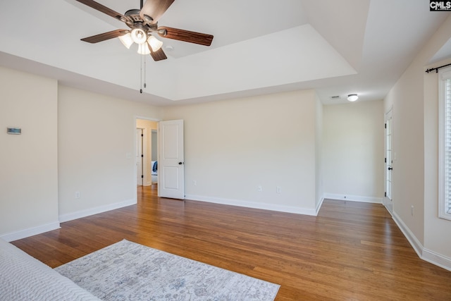 unfurnished room featuring baseboards, a ceiling fan, and wood finished floors