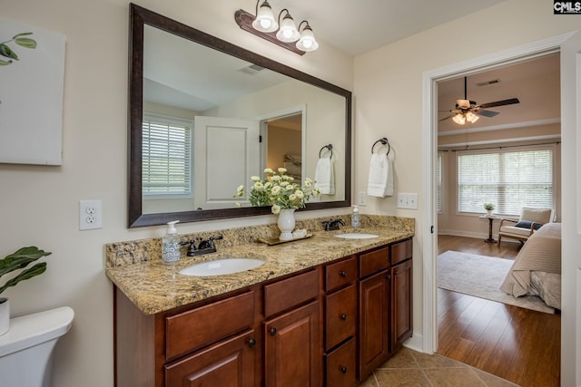 ensuite bathroom with ensuite bathroom, a sink, double vanity, and toilet