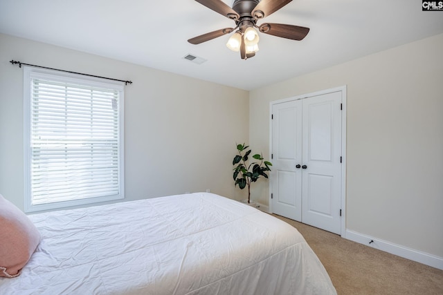 bedroom with visible vents, a ceiling fan, a closet, baseboards, and carpet flooring