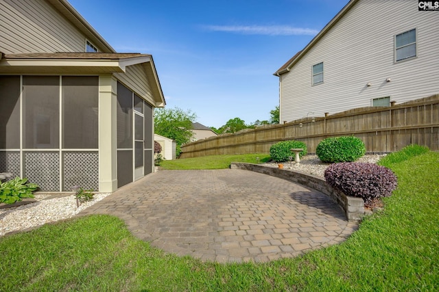 view of yard featuring fence, a patio, and a sunroom
