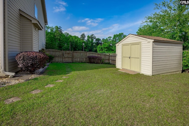view of yard featuring an outbuilding, fence, and a storage shed
