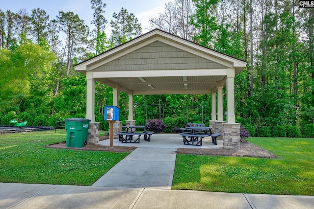 view of property's community featuring a lawn and a patio area