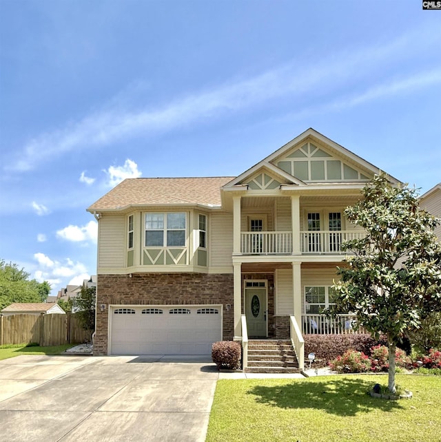 craftsman-style home featuring covered porch, driveway, fence, a balcony, and an attached garage