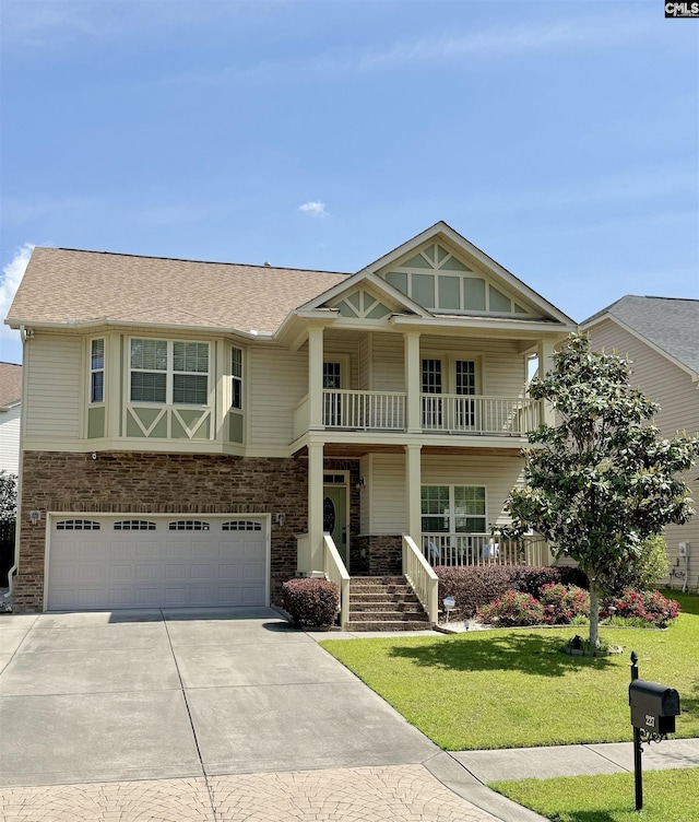 craftsman-style home featuring covered porch, driveway, a garage, a balcony, and a front lawn