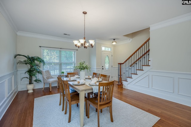 dining space featuring a decorative wall, plenty of natural light, a notable chandelier, and visible vents