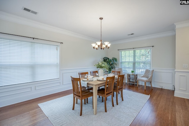 dining room featuring ornamental molding, a notable chandelier, light wood-style flooring, and visible vents