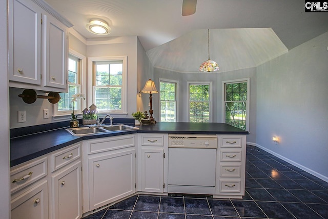 kitchen with dark tile patterned floors, white dishwasher, dark countertops, white cabinets, and a peninsula