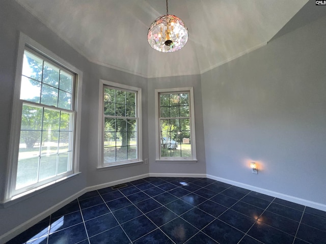 unfurnished dining area with dark tile patterned floors, baseboards, and vaulted ceiling
