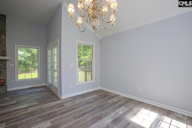 unfurnished dining area with an inviting chandelier, a high ceiling, dark wood finished floors, and baseboards