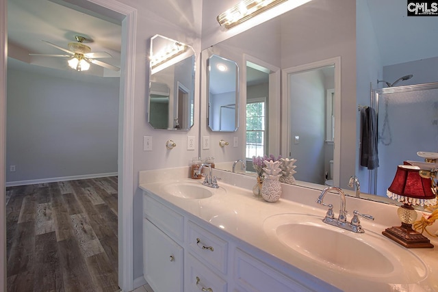 full bath featuring double vanity, toilet, a ceiling fan, and a sink