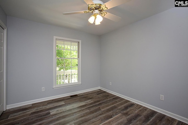 spare room with dark wood-style flooring, baseboards, and a ceiling fan