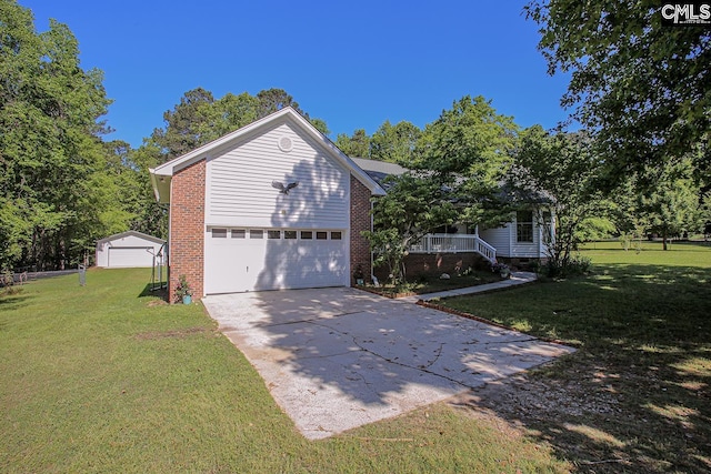 view of side of home with a yard, driveway, covered porch, and a garage