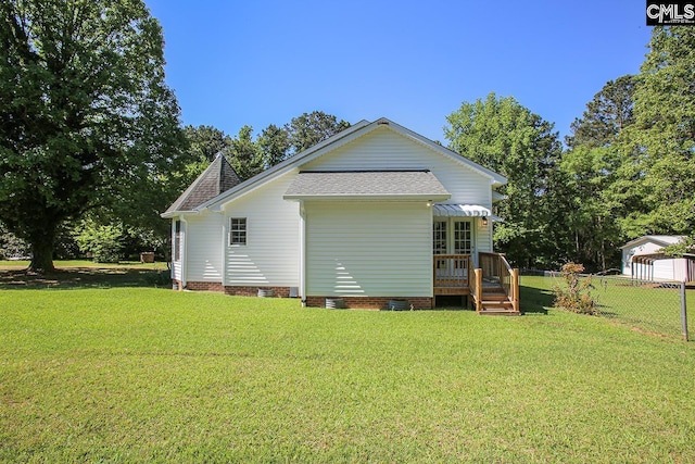 rear view of property featuring a lawn, crawl space, fence, and a shingled roof