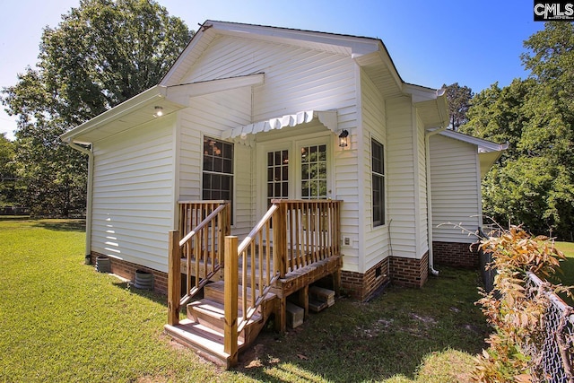 back of house featuring a lawn and crawl space