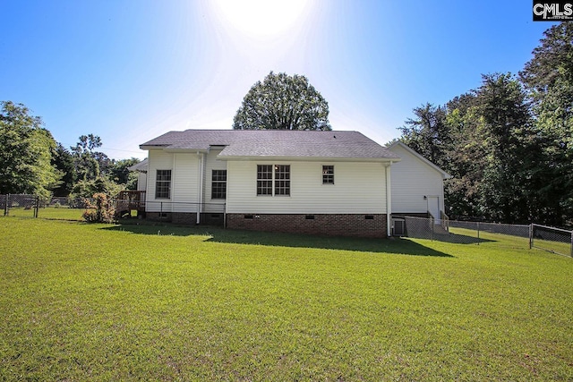back of house featuring a lawn, crawl space, and a fenced backyard