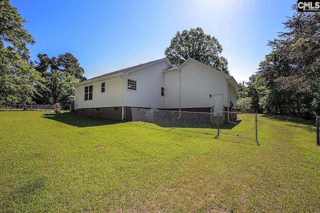 rear view of property featuring fence, a yard, and crawl space