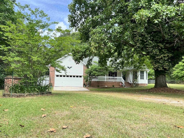 obstructed view of property with driveway, covered porch, and a front yard