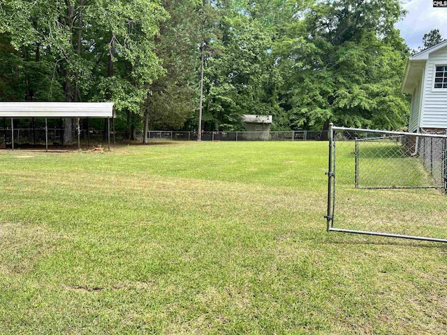 view of yard with fence and a carport