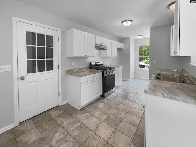 kitchen with a sink, white cabinetry, baseboards, gas range, and under cabinet range hood