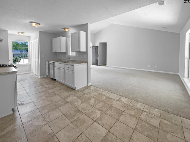 kitchen featuring baseboards, stainless steel dishwasher, a textured ceiling, and light carpet