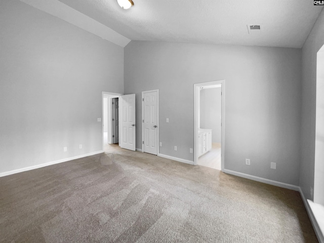 unfurnished bedroom with carpet flooring, high vaulted ceiling, visible vents, and baseboards