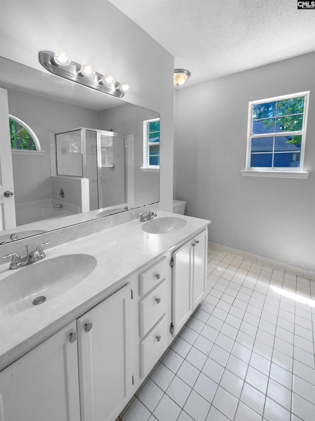 full bathroom with double vanity, a sink, a stall shower, and tile patterned floors