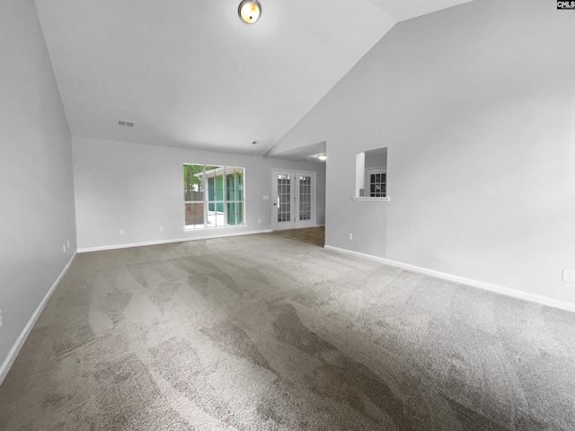empty room with carpet floors, visible vents, baseboards, high vaulted ceiling, and french doors