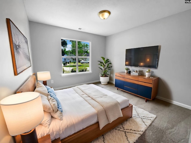 bedroom with visible vents, baseboards, and light colored carpet