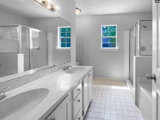 bathroom featuring a sink, tile patterned floors, a shower stall, and double vanity