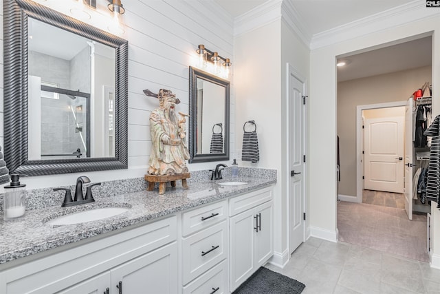 bathroom featuring a sink, baseboards, a stall shower, and double vanity